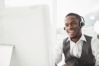 Smiling businessman with headset interacting in his office