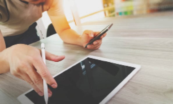 top view of Designer hand working with digital tablet computer and smart phone on wooden desk as responsive web design concept